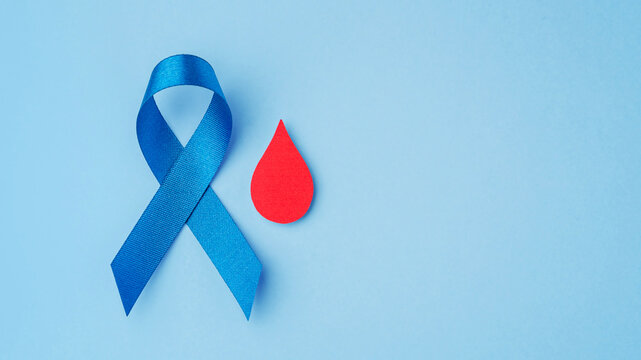 Blue ribbon with red blood drop on blue background with copy space, World Diabetes Day concept