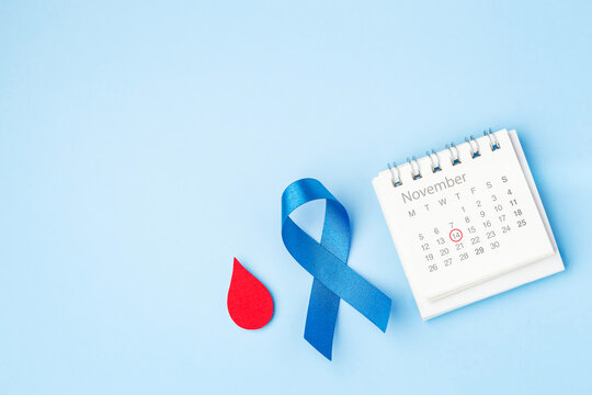 Diabetes day awareness, Blue ribbon with red blood drop and November calendar with mark on 14 on light blue background, top view