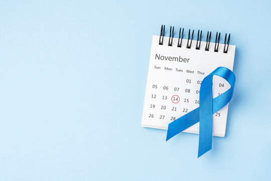 Diabetes day concept, Blue ribbon on November calendar with mark on 14 on light blue background, top view