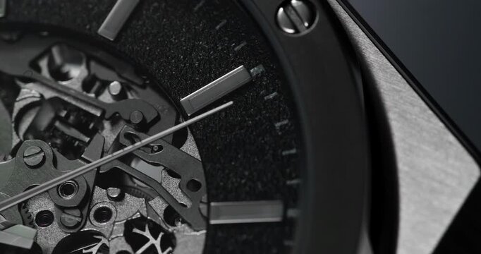 Macro close up of luxury skeleton watch face with exposed gears and sweeping second hand