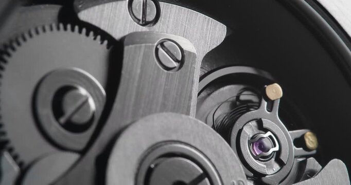 Macro close up of mechanical watch movement with oscillating balance wheel and gears