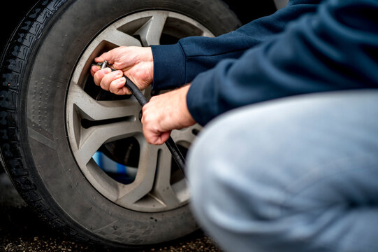 Hand's of man filling air in tire at gas station