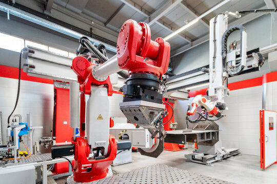Large red industrial robotic arm in a modern manufacturing facility