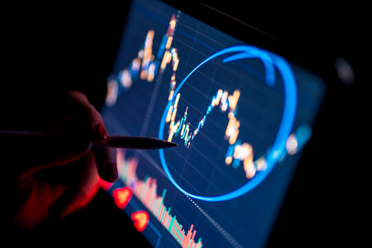 Female business professional analyzing stock market graph through digital tablet