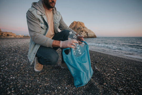 Man collecting trash from coastline at beach