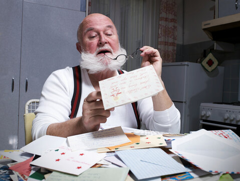 Santa reading a Christmas letter in the kitchen at night