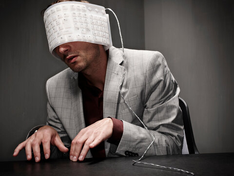 Businessman typing with flexible keyboard wrapped around head