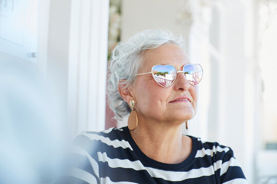 Senior woman in heart sunglasses contemplating outdoors