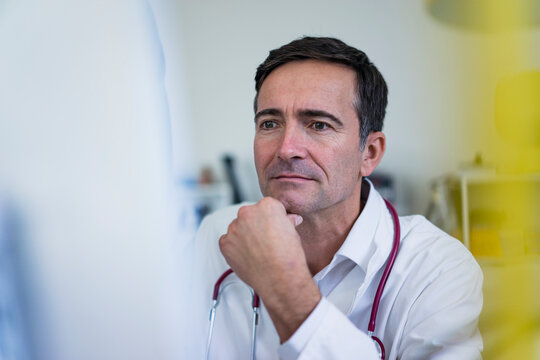 Doctor in medical practice looking at computer