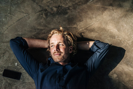 Man lying on floor next to cell phone