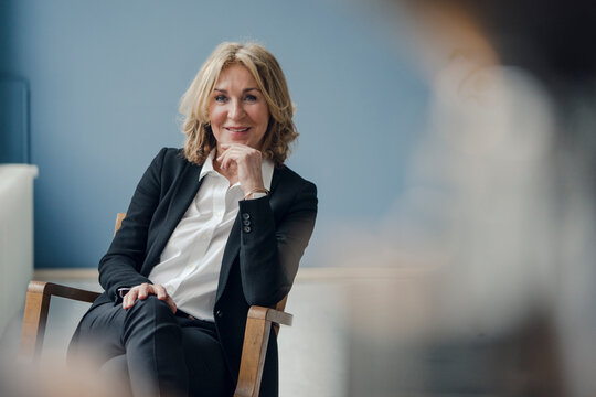 Portrait of smiling senior businesswoman sitting in chair
