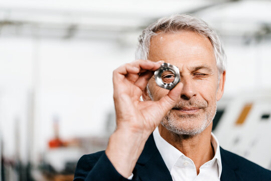 Manager in high tech enterprise, checking machine parts