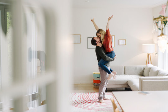 Man lifting and embracing his cheering wife