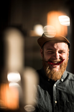 Laughing man biting a red chili pod