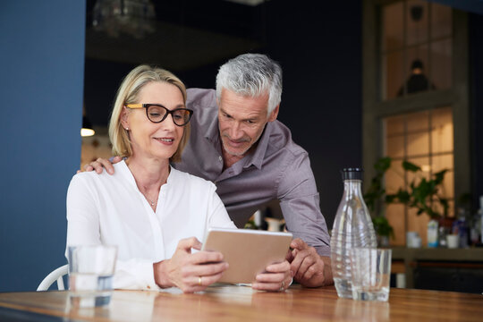 Mature couple using tablet at home