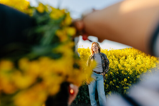 Photographing friend outside in a yellow spring flower field