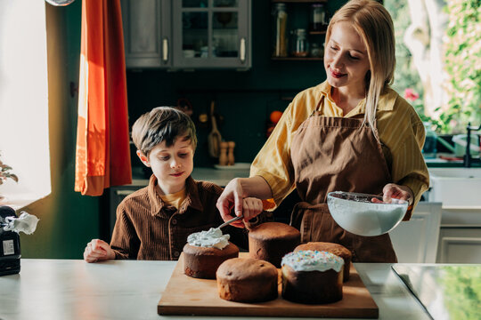 Mother and son decorating Easter bread in the kitchen