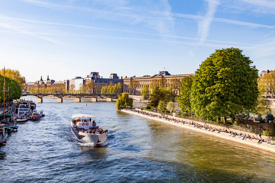 France, Paris, Tourist boat on Seine river with Louvre in background