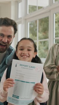 Family, face or home with child for report card, good results or well done together. Celebration, mom or dad with excited kid, jump or paper for academic record, term end or semester success in house