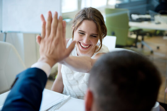 Happy businesswoman and businessman high fiving