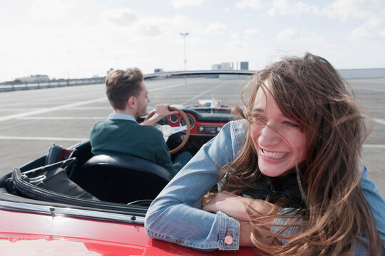 Smiling woman and man driving a convertible outdoors in Berlin