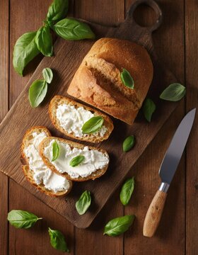 Wooden table with fresh ricotta basil bread and knife 