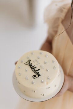 Girl holding small minimalist birthday cake