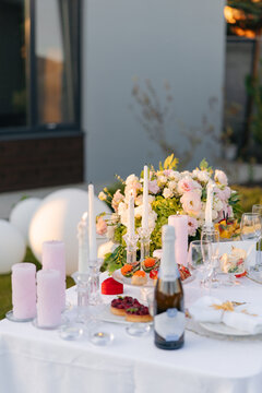 Outdoor romantic dinner party table setting with flowers and candles