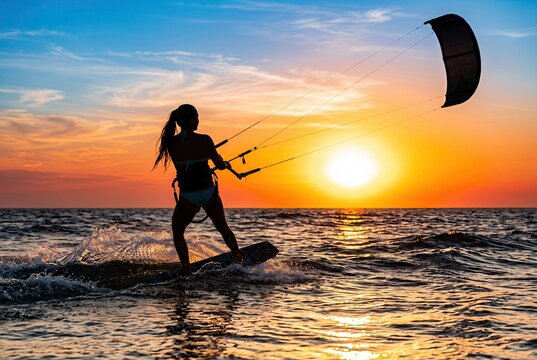 Generated ai Silhouette of Kitesurfer Riding Waves at Sunset