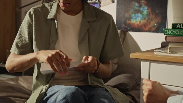 Handheld shot of Black teenager opening college acceptance letter and hugging Caucasian middle aged mother in celebration. Clip perfect for university marketing and family financial planning ads