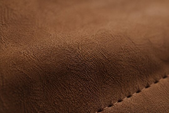 Extreme close-up of nubuck leather texture showing fibrous structure under natural window light.