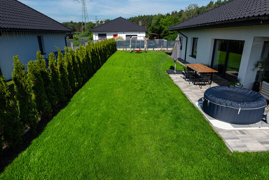 Backyard lawn with hot tub and garden hedge