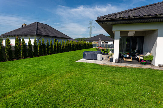 Modern house garden featuring green lawn and outdoor jacuzzi