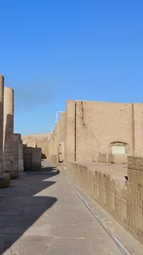 Kom Ombo temple ruins with double columns and composite capitals against clear blue sky in Egypt, ancient Ptolemaic architecture dedicated to Sobek and Horus with damaged walls