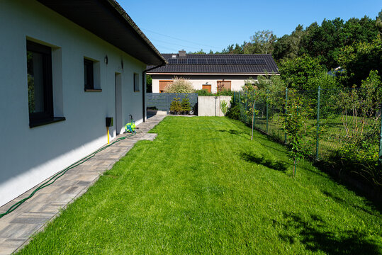 Modern house with well kept green lawn and backyard garden