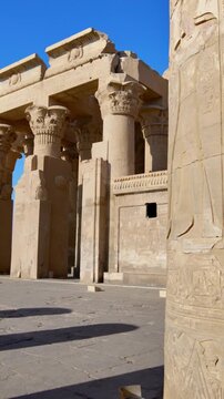 Kom Ombo temple ruins with double columns and composite capitals against clear blue sky in Egypt, ancient Ptolemaic architecture dedicated to Sobek and Horus with damaged walls