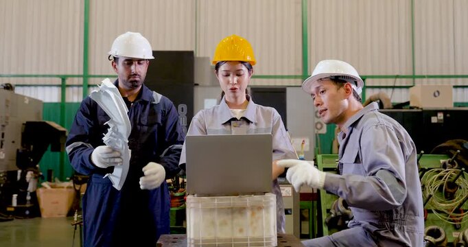 Asian factory staff study molded part near laptop, comparing machine condition, production update, technical detail, safety step, digital tracking in during slow motion teamwork review.