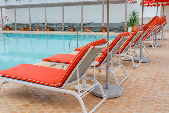 Empty swimming pool with sunbed and beach umbrella in resort hotel for vacation leisure and white sand,resort neary sea and beach in summer.