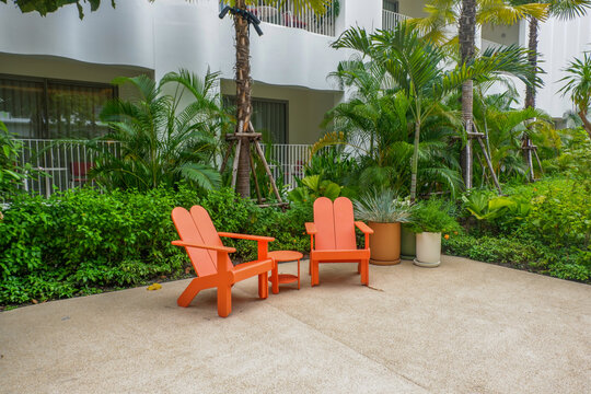 Wooden table and bench chair set in garden on a sunny day,outdoor seating for restaurant or cafe,Neat paved patio with sitting area and small garden in forest.