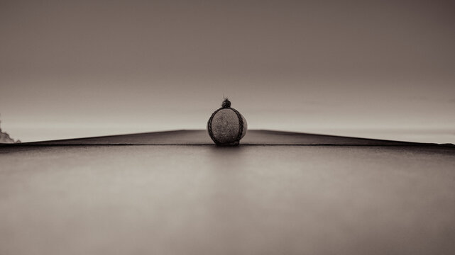 Single stone balanced on dark surface minimalist monochrome