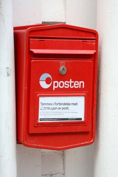 FLEKKEFJORD, NORWAY - JULY 19, 2020: Red post box of Posten Norge (The Norwegian Post) in Flekkefjord. Posten was founded in 1647.