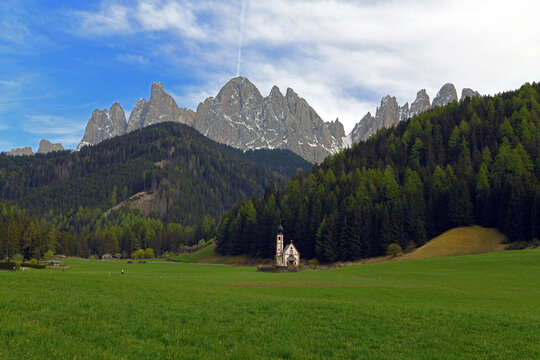 Church of San Giovanni in Ranui, an iconic baroque chapel located in Val di Funes, in South Tyrol. In the background stand the Odle (Geisler), a famous mountain group of the Dolomites, recognized as a