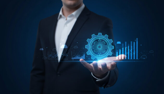 Businessman holding digital infographic with gear and charts representing business growth and technology.