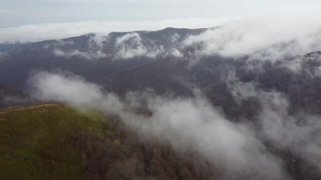 Cinematic drone flight over mountain ridge and rolling clouds