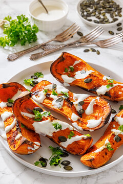 Baked butternut squash halves with yogurt sauce