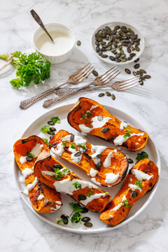 Baked butternut squash halves with yogurt sauce