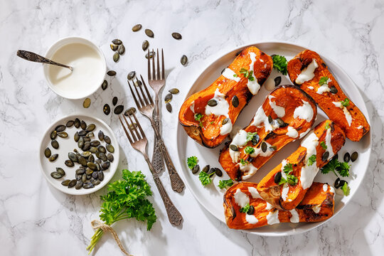 Baked butternut squash halves with yogurt sauce