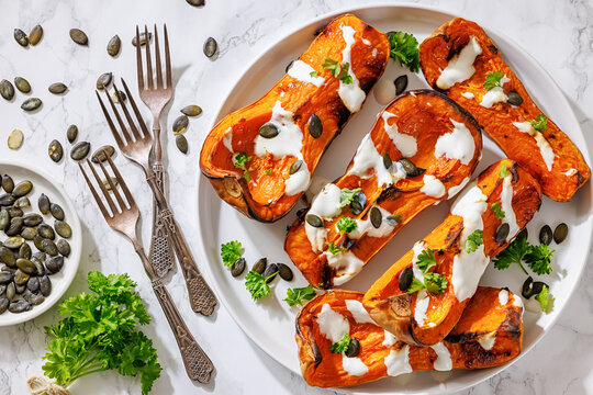 Baked butternut squash halves with yogurt sauce