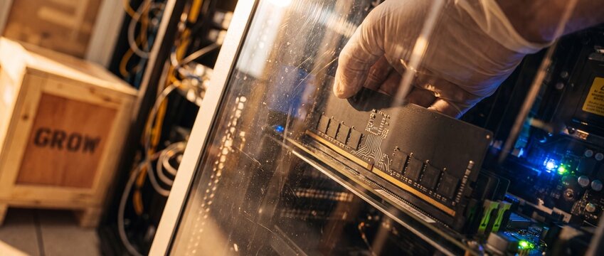 Installing RAM memory module computer server hardware upgrade in tech laboratory, IT technician hand in white glove upgrading workstation motherboard components, professional data center system build.
