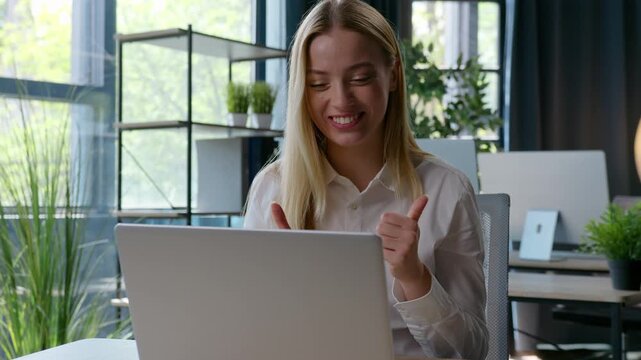 Happy smiling friendly Caucasian businesswoman talking video call greeting hello showing thumb up business woman female girl talk conference laptop virtual chat smile communicate speak at office table